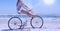 Composition of woman riding bike on beach with copy space