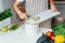 Compost the kitchen waste, recycling. Household woman scraping, throwing vegetables cutting leftovers into the garbage