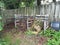 Compost piles of weeds and sticks and wood fence