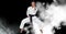Compostion of caucasian male karate fighter on black background with white blur