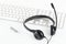 Computer headset with microphone on computer keyboard on white t