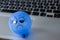 Computer keyboard with a blue balloon with a sad face drawn on it symbolizing the blue Monday.