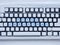 Computer keyboard covered with white snow with inscription merry christmas on buttons