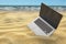 Computer laptop in the sand of the sea or ocean beach. Freelance