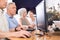 Computer lessons for elderly people in nursing home. Group of seniors learning to use computers in class