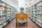 Computer in a library with many books and shelves