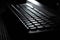 Computer wireless keyboard on wooden table background on the office in moonlight