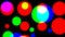 Computerized animation of colorful circles of various sizes, flickering with various intensity, on black background