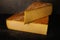 Comte cheese on dark background. Aged french cheese made from unpasteurized cow`s milk