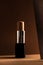 Concealer stick, on geometric backgrounds, in shades of brown. Product