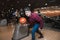 Conceiving a young man going to throw a ball for bowling. Student playing bowling. A look at the camera.