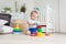 Concentrated adorable toddler boy sitting on floor and building toy tower