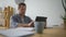 Concentrated adult man sitting at the table