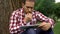 Concentrated adult men using tablet in park, reading article about mens health