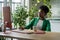 Concentrated African American woman manager of successful startup sits at computer desk in office