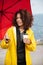 Concentrated african curly young lady walking outdoors and drinking coffee.