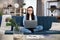 Concentrated asian young woman in headset having video call on laptop