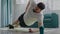 Concentrated athlete with beard stands in plank pose on hand