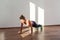 Concentrated athletic beautiful woman with bun hairstyle and in tight sportswear practicing. indoor studio shot illuminated by