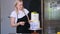 Concentrated blonde woman in apron finishing decorating gluten free cake with leaves and lemons