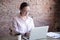 Concentrated businesswoman with glasses looking at laptop.