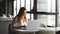 Concentrated businesswoman working on a laptop in a cafe near the window