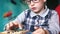 Concentrated Caucasian boy 5 - 7 years old wearing glasses at home doing arithmetic homework, home teaching children, arithmetic c