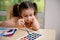 Concentrated Caucasian preschooler girl mixing watercolors paints with a brush on a palette. Creative art class for kids