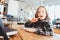 concentrated child girl doing homework. Thoughtful school kid thinking and looking for an answer