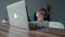 Concentrated child in headphones plays video game on laptop