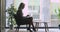 Concentrated confident older businesswoman sitting near window, working on computer.