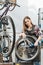 Concentrated craftswoman repairing the wheel in the garage