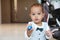 Concentrated cute toddler boy in suit with bowtie showing toy care