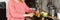 A concentrated elderly woman slicing vegetables and looking down in the kitchen