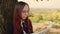 Concentrated elegant lady reading newspaper in park. Focused young female entrepreneur with long dye hair in formal wear