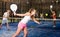 Concentrated energetic girl playing paddle tennis indoors