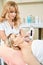 Concentrated female beautician doing microneedle rf lifting of adult woman