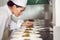 Concentrated female chef garnishing food in kitchen