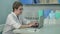 Concentrated female doctor in glasses typing on laptop in her office