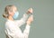 Concentrated female scientist in uniform takes a liquid by pipette from a test tube for some research in a laboratory