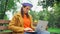 concentrated freelancer in autumn clothes typing on laptop in park.