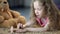 Concentrated girl painting nails with mothers polish, pretending to be older