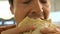 Concentrated guy holds lavash with falafel and chews close-up