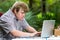 Concentrated handicapped boy typing on laptop.