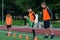 Concentrated junior soccer player running among orange cones that standing on artificial turf at stadium during workout