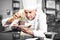 Concentrated male pastry chef decorating dessert in kitchen