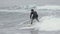Concentrated male surfer sportsperson in wetsuit riding breaking wave in Pacific Ocean. Slow motion shot