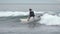 Concentrated male surfer sportsperson in wetsuit riding wave in Pacific Ocean on Kamchatka. Slow motion shot