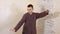 Concentrated man practicing tai chi martial gymnastics on wooden wall background. Fit young man training traditional