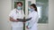 Concentrated man and woman discussing medical history standing in hospital corridor. Intelligent professional doctor and